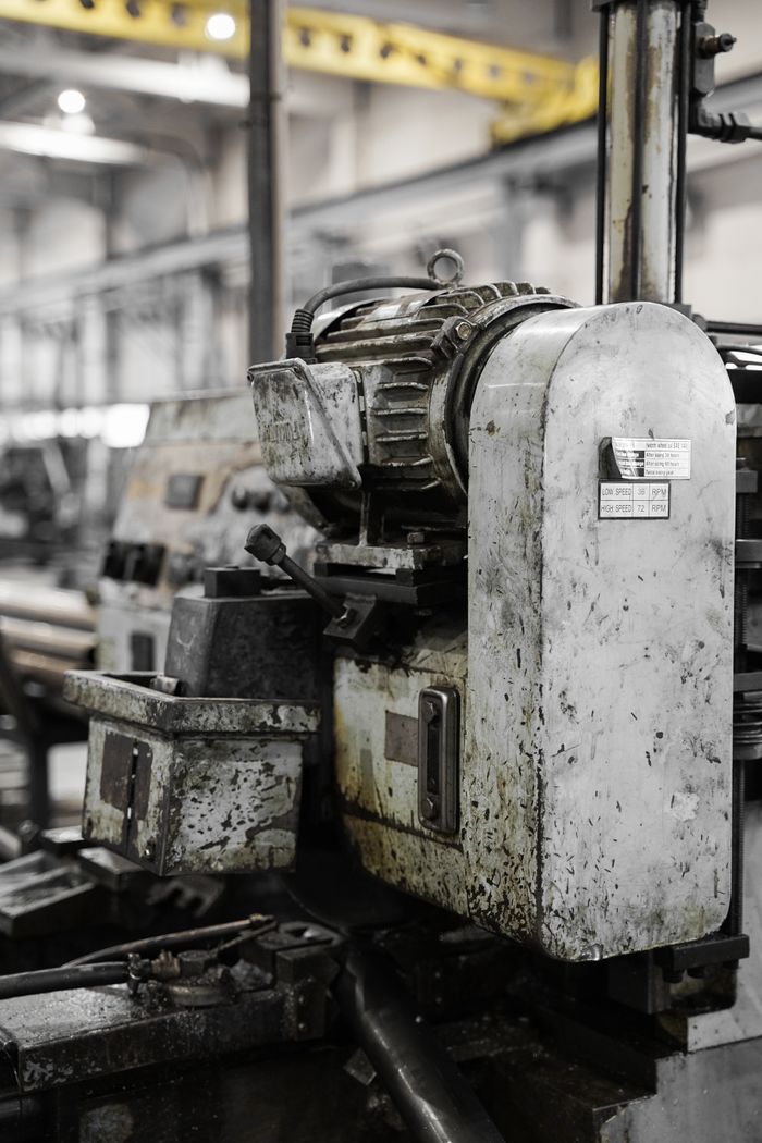 Services Greasy industrial machinery in a factory showcasing heavy equipment and metalwork.