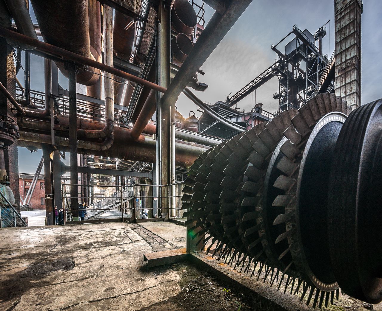 Services Detailed view of large industrial machinery in a factory with steel structures and pipes.